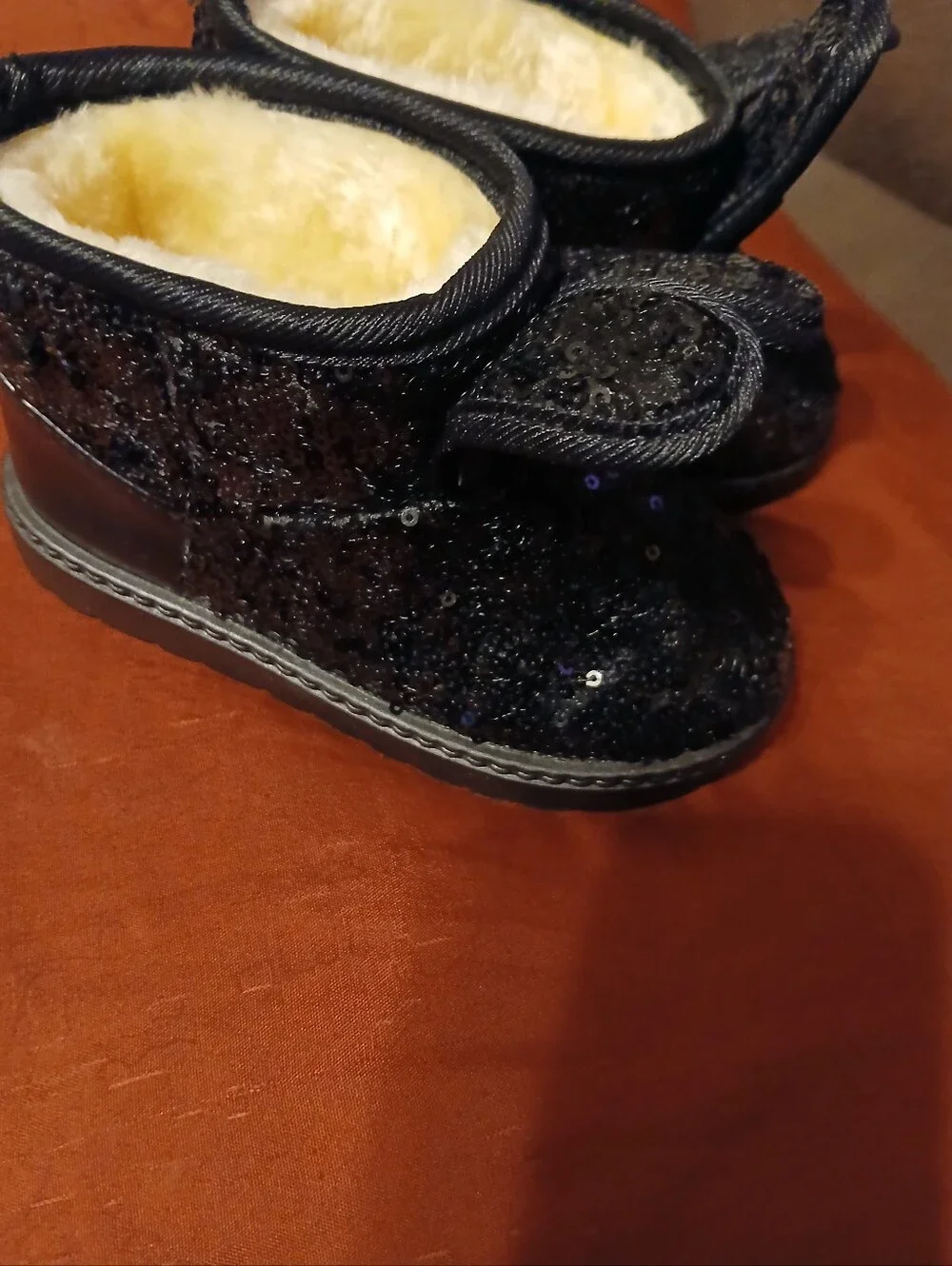 black sequin children's ankle boots with decorative bows and flat fur sole